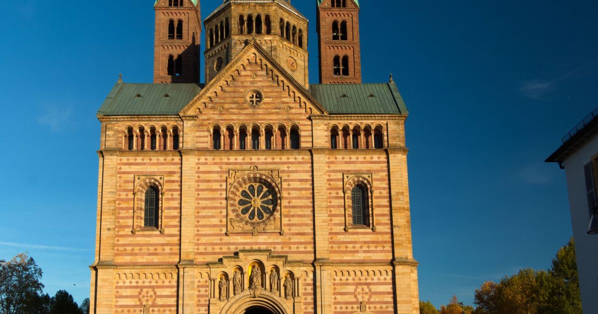 Fachada de una catedral románica de piedra iluminada por la luz dorada del atardecer