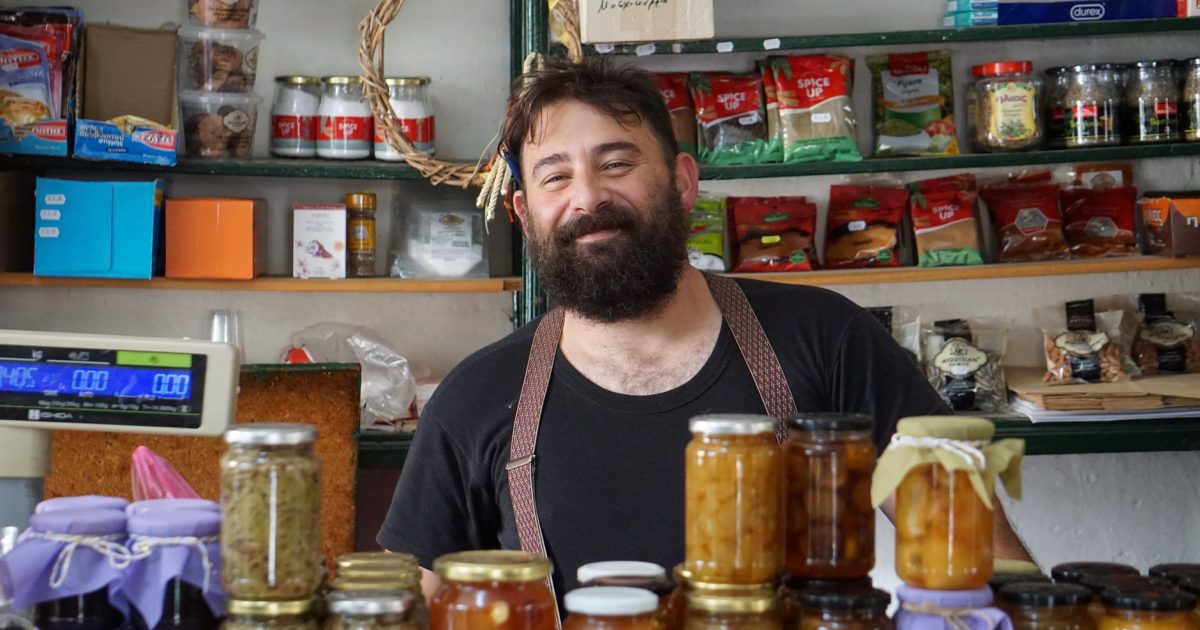 Tendero sonriente tras los estantes de una tienda de alimentación pequeña, de las que hay en los pueblos del Camino
