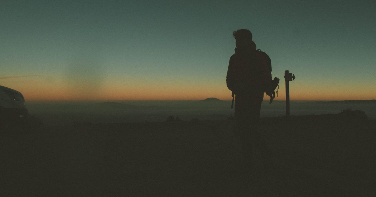 peregrino caminando montaña al atardecer con mochila